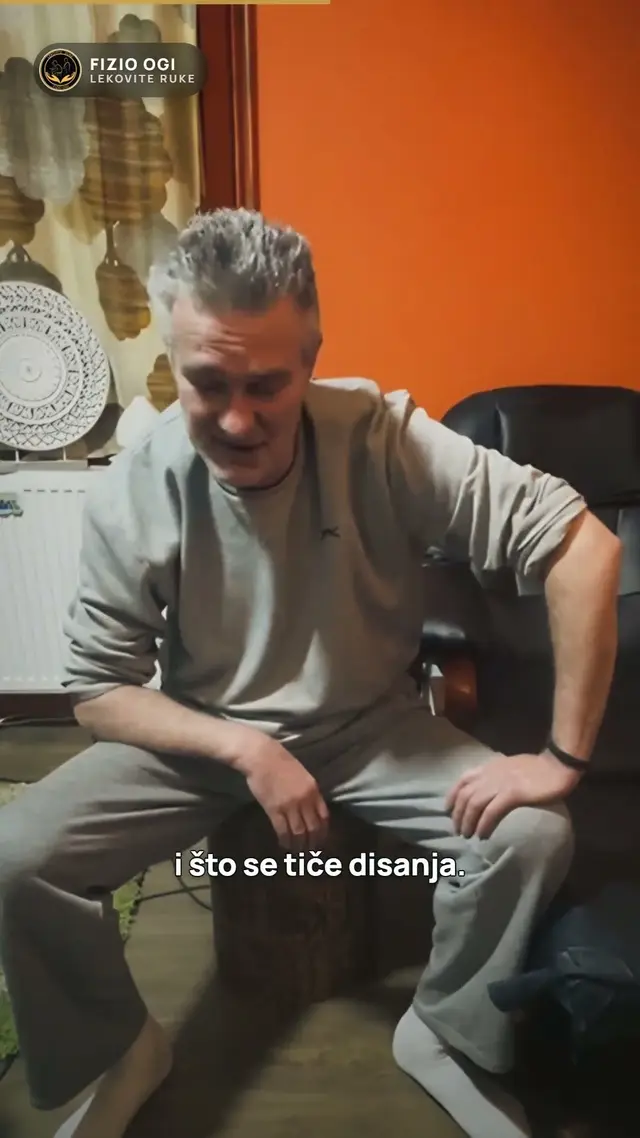 Čovek sedi na ivici stola u sali i pokazuje kako diše
